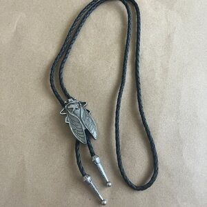 Western cicada bolo tie, featuring a silver tone metal insect pendant
